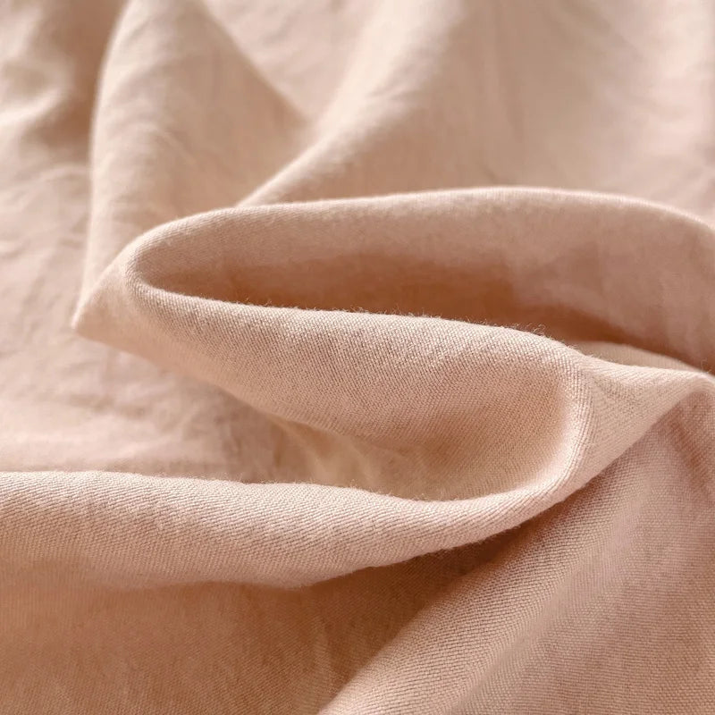 Set of two ultra-soft cotton-blend pillowcases in a minimalist solid colour, styled on a neutral-toned bed for a relaxed, cosy look.