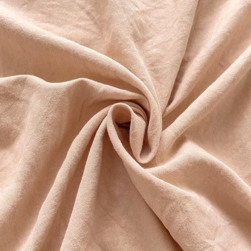 Set of two ultra-soft cotton-blend pillowcases in a minimalist solid colour, styled on a neutral-toned bed for a relaxed, cosy look.