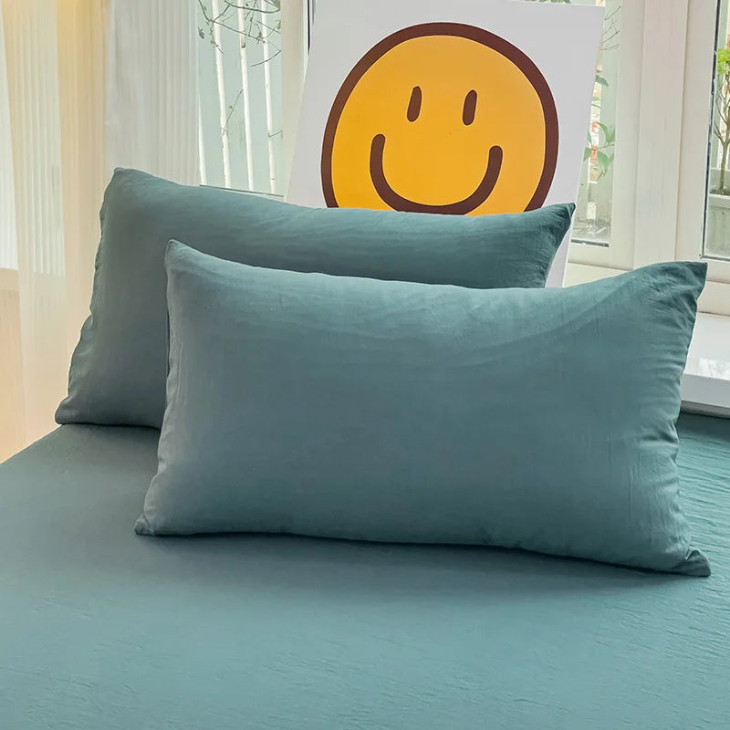 Set of two ultra-soft cotton-blend pillowcases in a minimalist solid colour, styled on a neutral-toned bed for a relaxed, cosy look.
