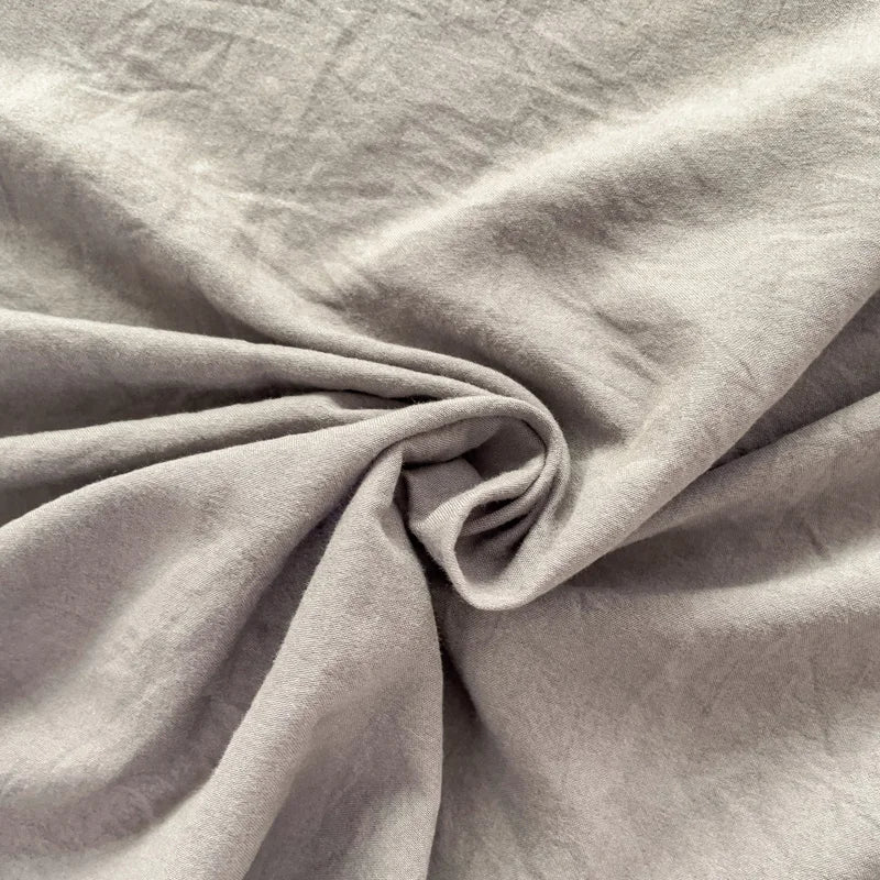 Set of two ultra-soft cotton-blend pillowcases in a minimalist solid colour, styled on a neutral-toned bed for a relaxed, cosy look.